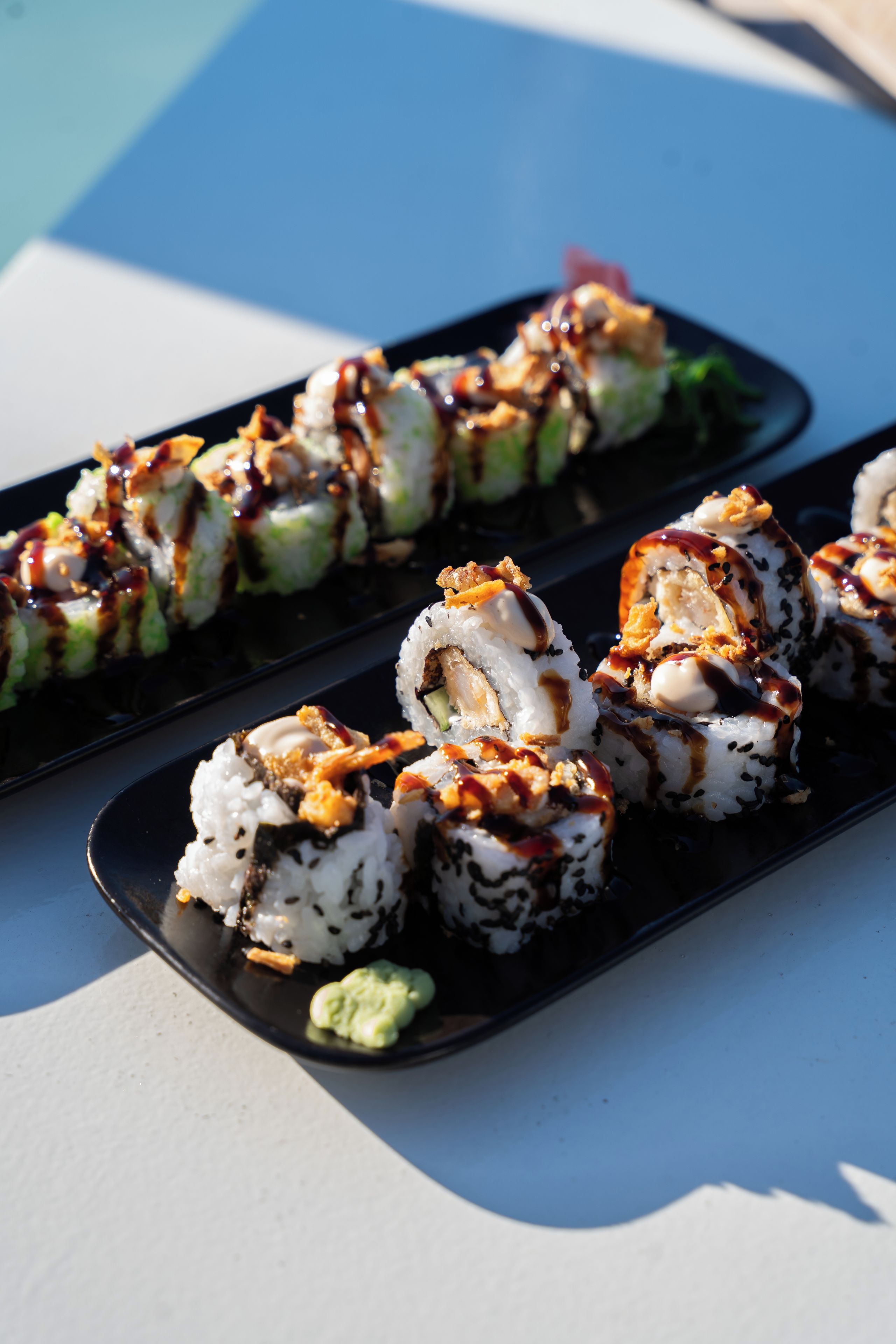 A sushi platter with various rolls and a small dish of wasabi.