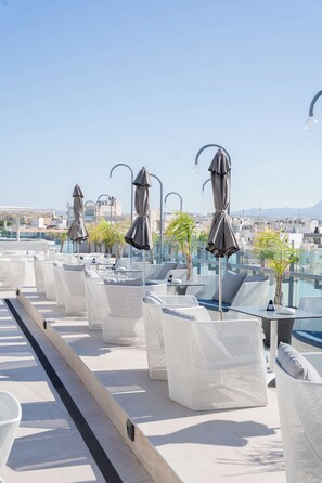 A rooftop terrace with outdoor seating and umbrellas, overlooking a cityscape. - Capsis Astoria Heraklion Hotel (Heraklion)