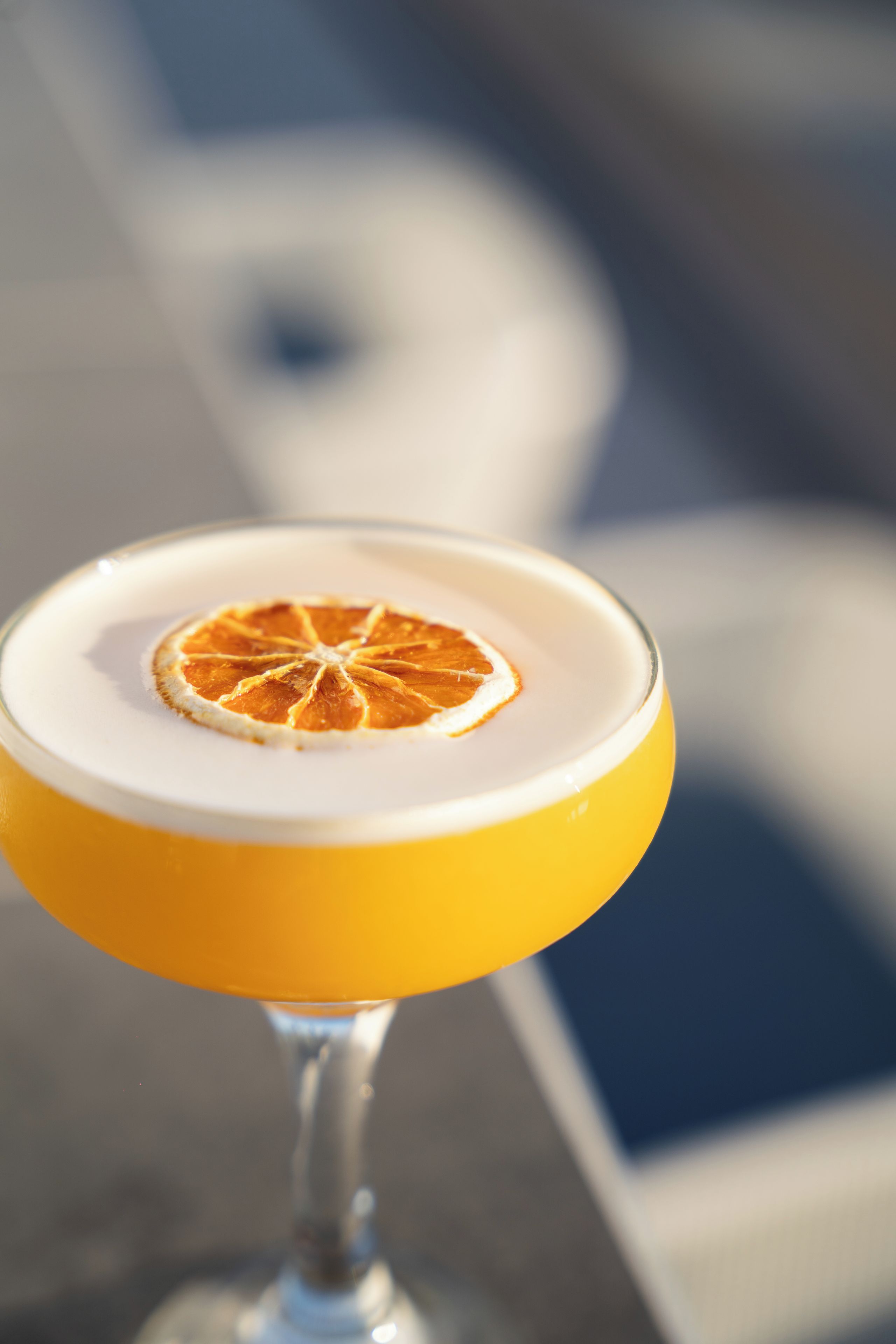 A cocktail in a glass with a citrus garnish.