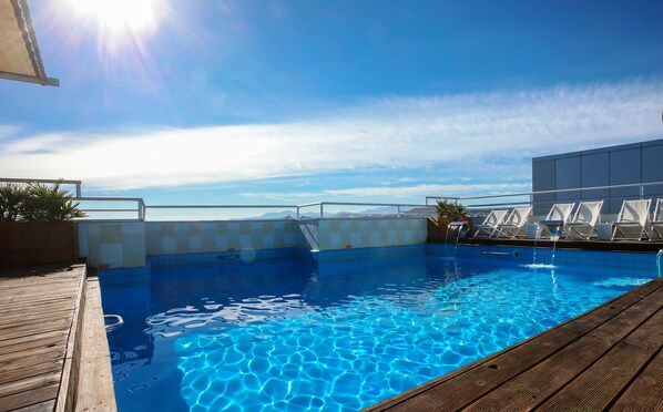 Seasonal outdoor pool, open 10:00 AM to 8:00 PM, pool umbrellas