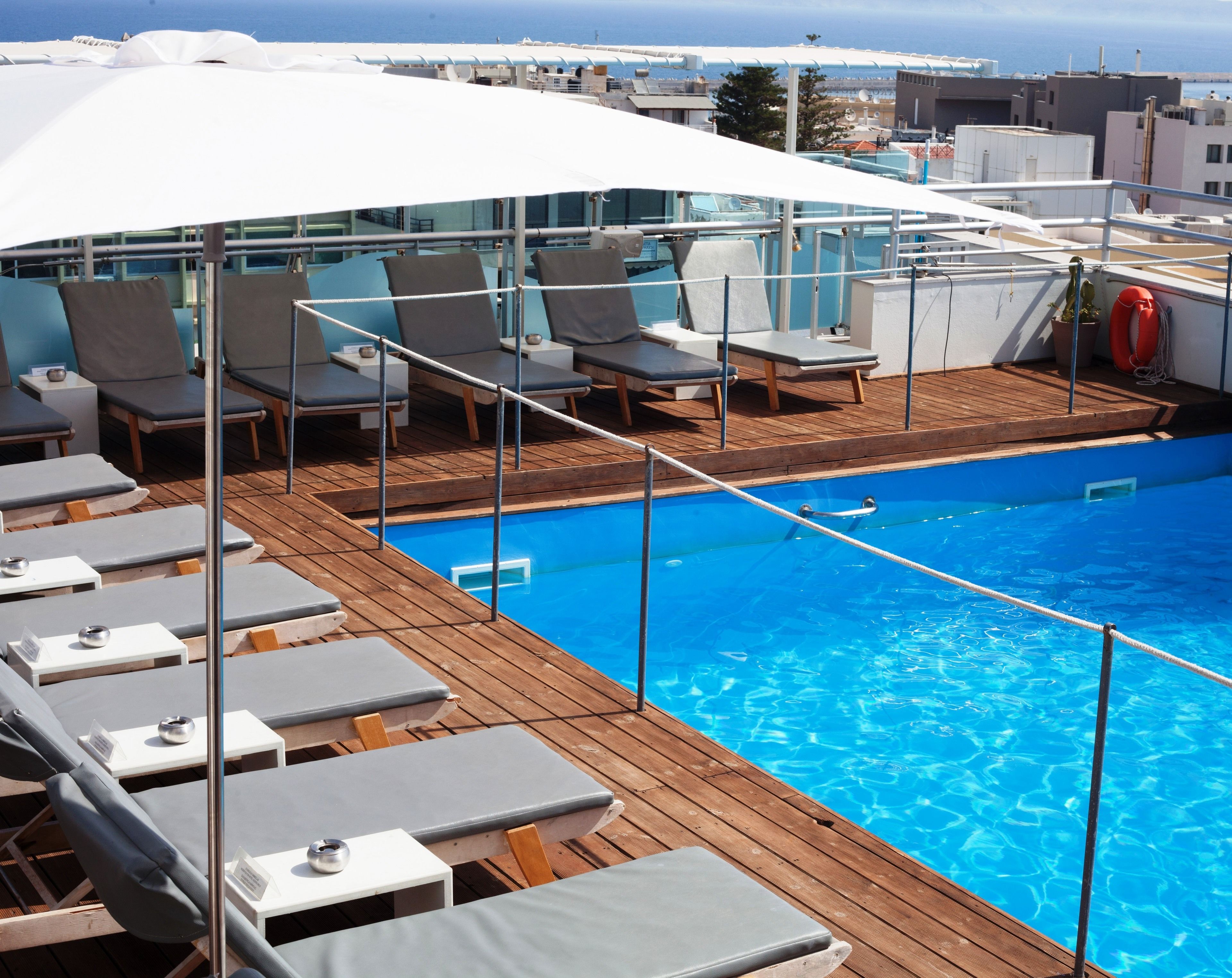 A poolside area with lounge chairs and a pool.
