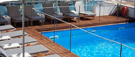 A poolside area with lounge chairs and a pool.