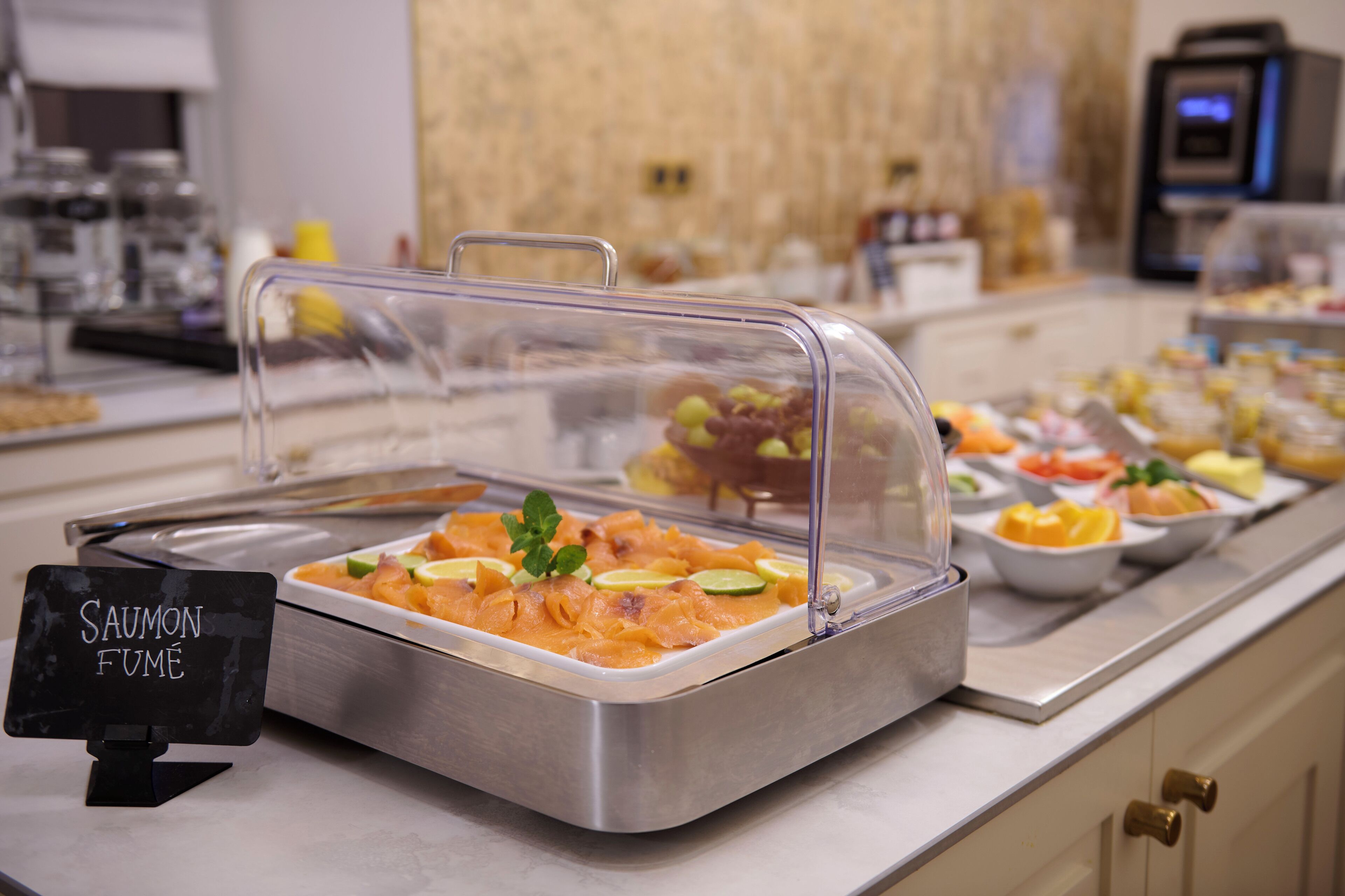 A buffet with a sign for 'Saumon Fume' and various food items.