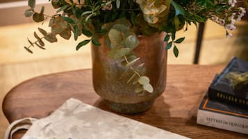 Uma mesa de madeira com um vaso de flores, um mapa e um livrete intitulado "Inwood Lovers".