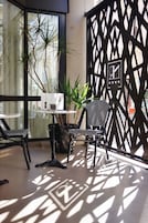 Un área de estar interior moderna con una mesa, sillas y un separador decorativo.