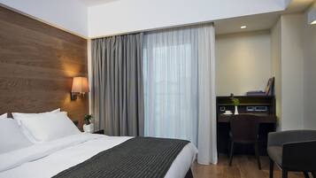 Une chambre d’hôtel avec un grand lit, un bureau et une chaise.