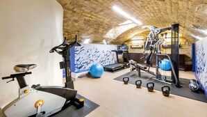 A gym with exercise equipment, a treadmill, and a blue exercise ball. - Hôtel Littéraire Arthur Rimbaud, BW Signature Collection (Paris)