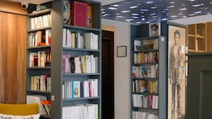 A library with bookshelves, a wooden floor, and a ceiling with a light fixture. - Hôtel Littéraire Arthur Rimbaud, BW Signature Collection (Paris)