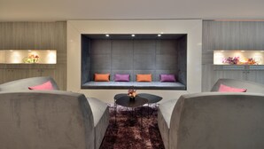 Una sala moderna con una zona de estar integrada, una mesa de centro y dos sillones.