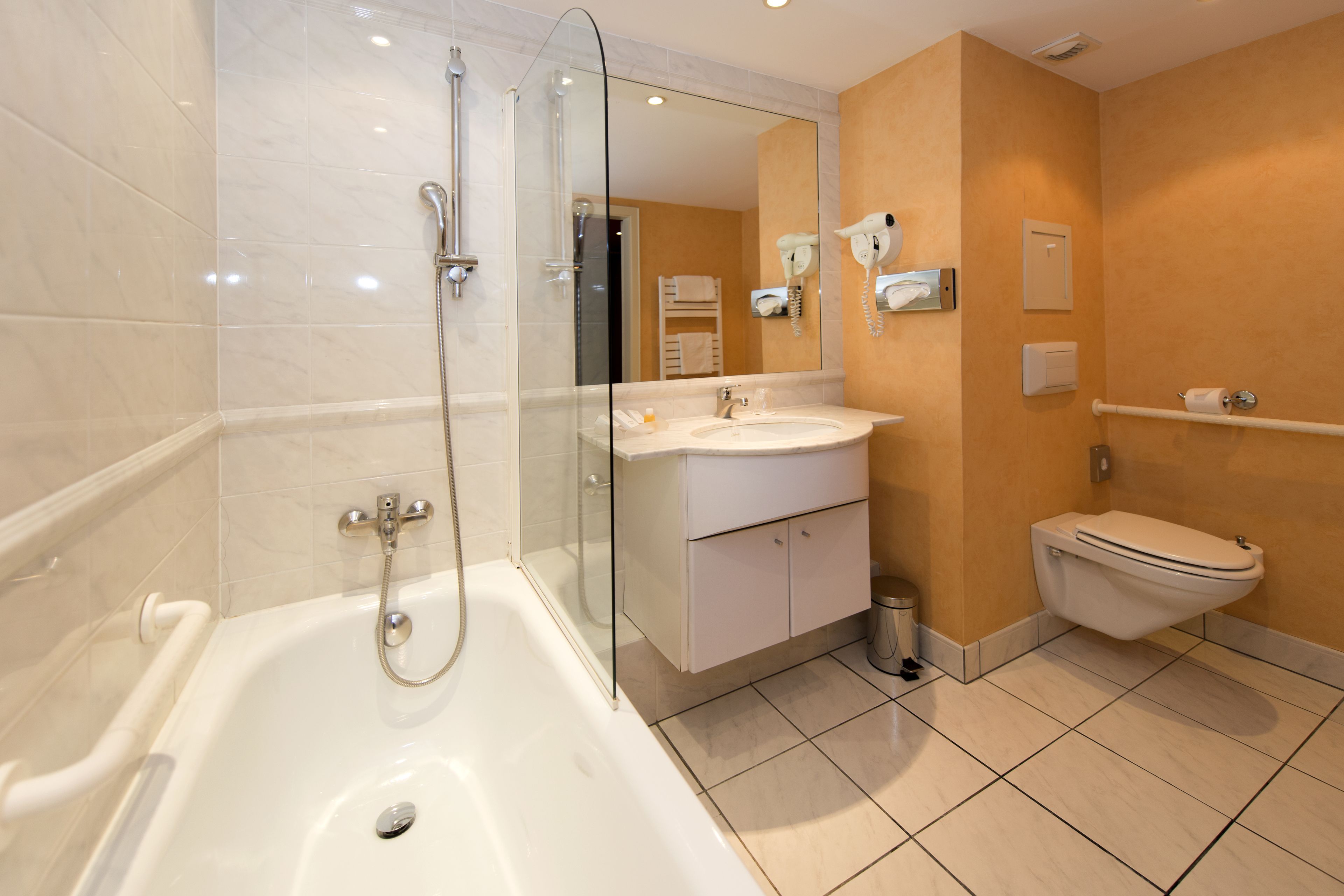 Ein modernes Badezimmer mit einer Duschkabine, einem weißen Waschbecken und einer Toilette.