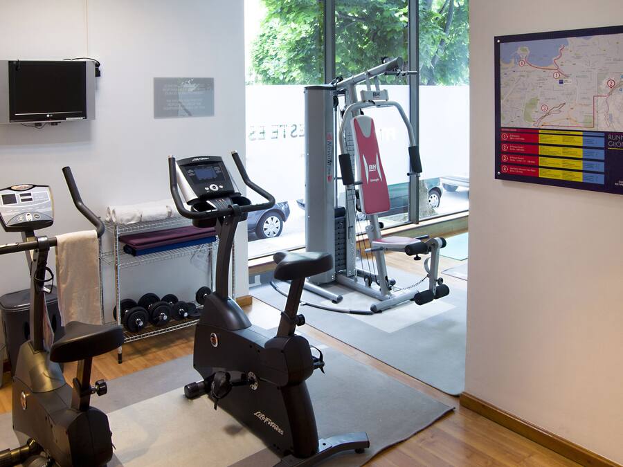 Academia com máquinas de cardio, equipamentos de musculação e um mapa das instalações.