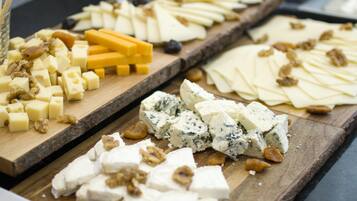 A variety of cheeses and nuts on wooden boards.