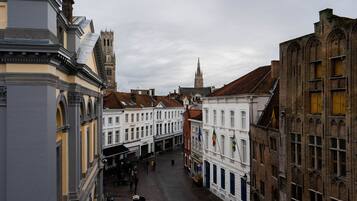 A historic street with traditional architecture, including a prominent church tower and a variety of building facades.