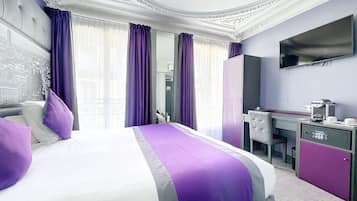 Une chambre d’hôtel avec un grand lit, un bureau avec un ordinateur, une télévision et une machine à café.
