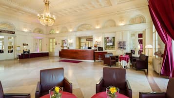 Un'ampia hall con reception, zone relax e un lampadario.