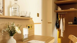 Un mostrador de recepción de madera con un florero, un certificado enmarcado, una botella de licor y un vaso.