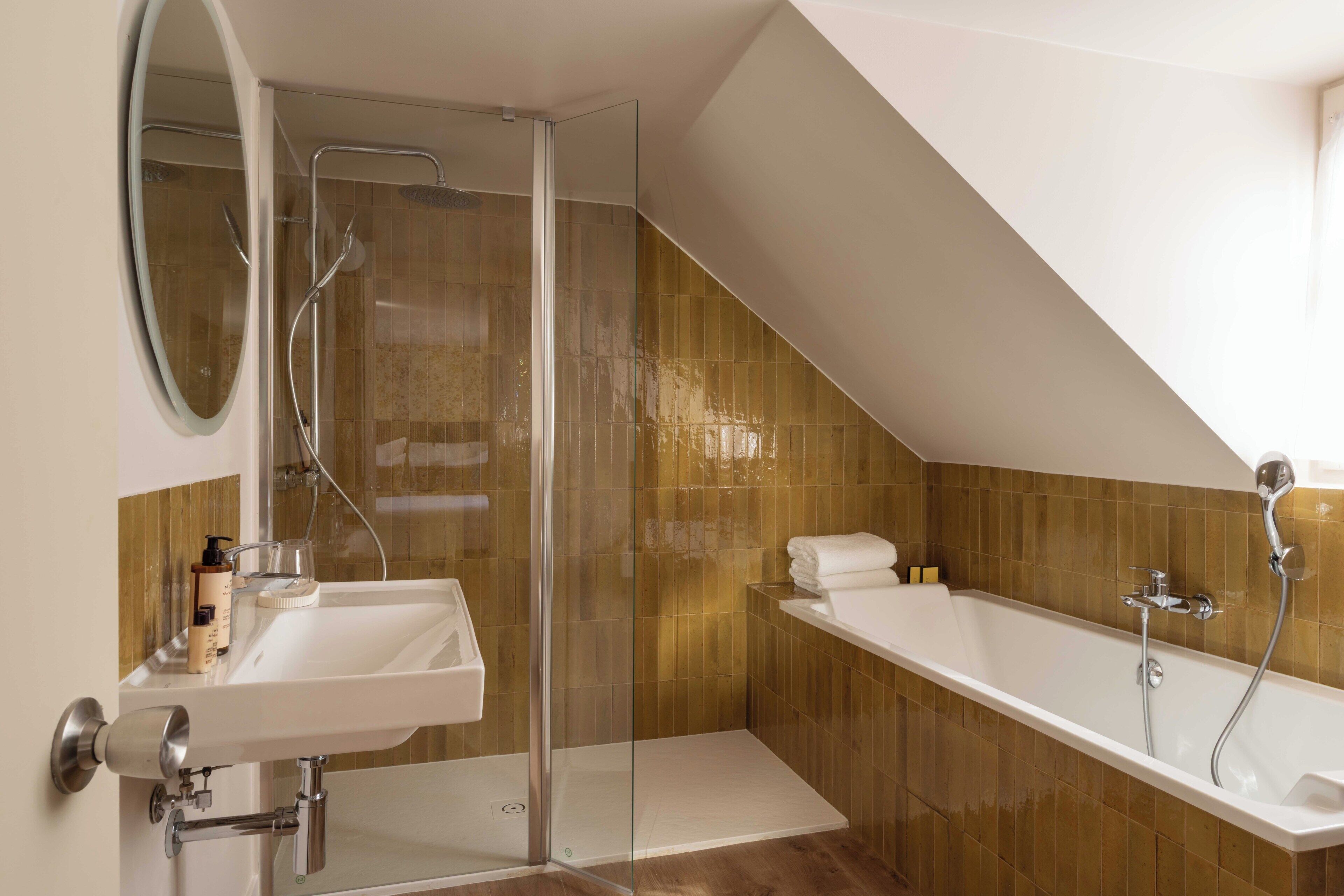 A modern bathroom with a glass shower enclosure, a white sink, and a freestanding bathtub.