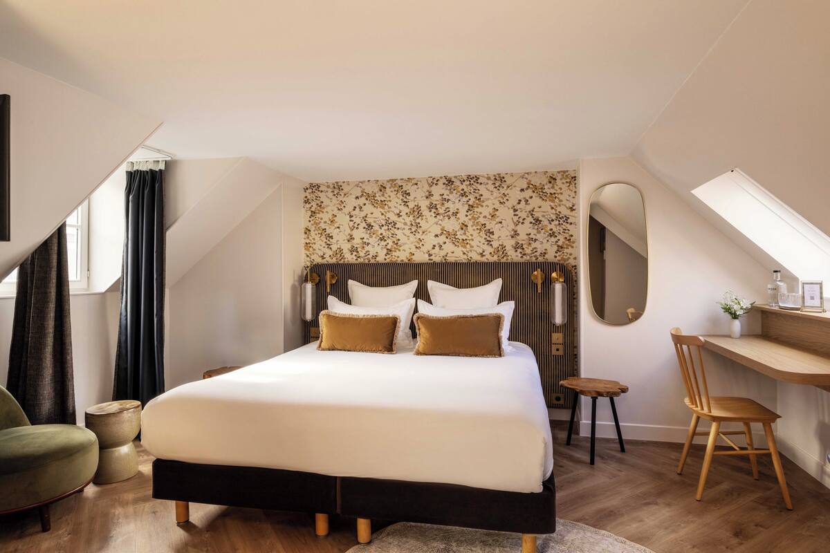A bedroom with a bed, a desk, a chair, and a window.