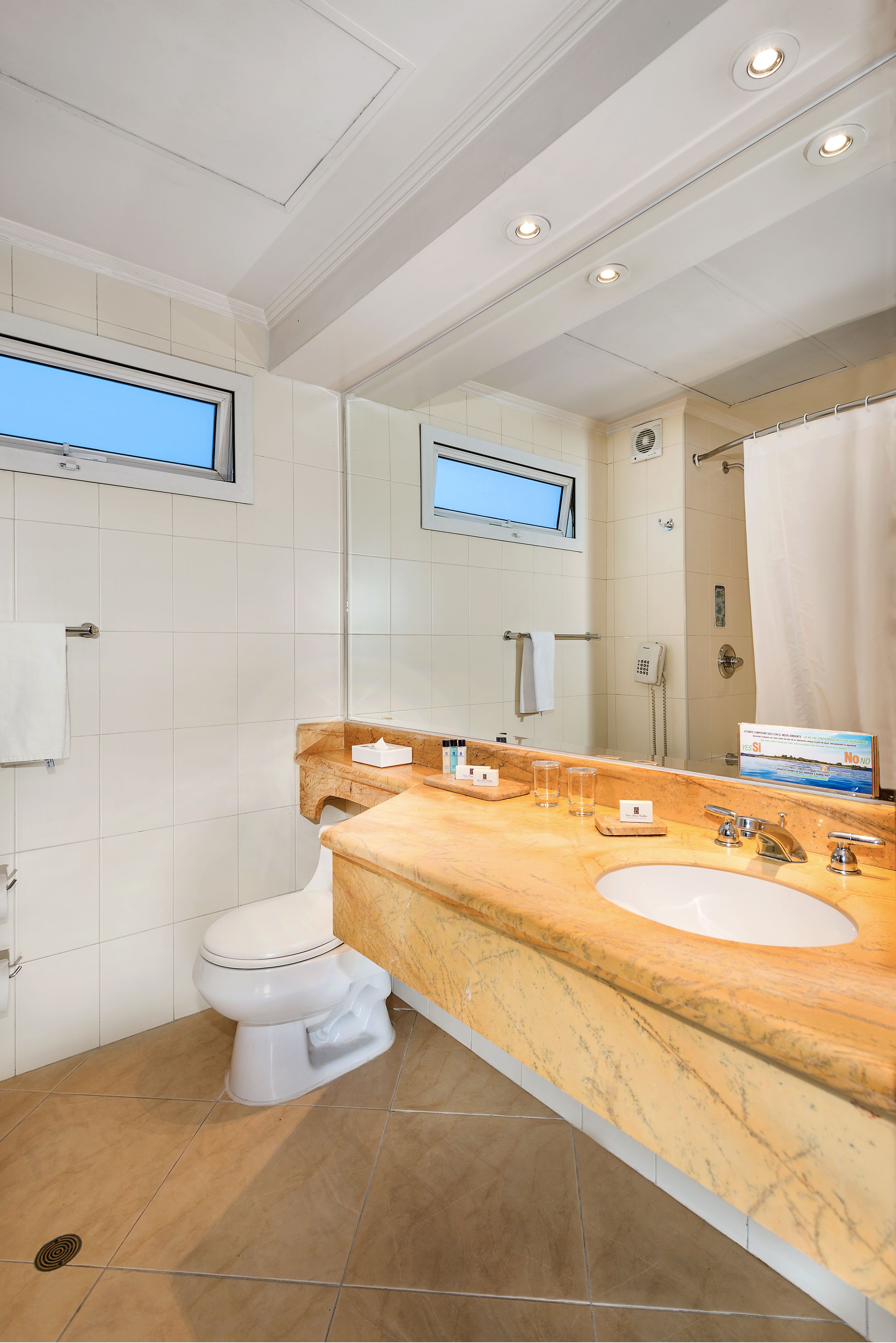 Une salle de bain moderne avec un lavabo en marbre, des toilettes et une douche.