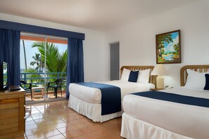 A hotel room with two beds, a desk, a chair, and a view of palm trees. - Whala!boca Chica (Boca Chica)