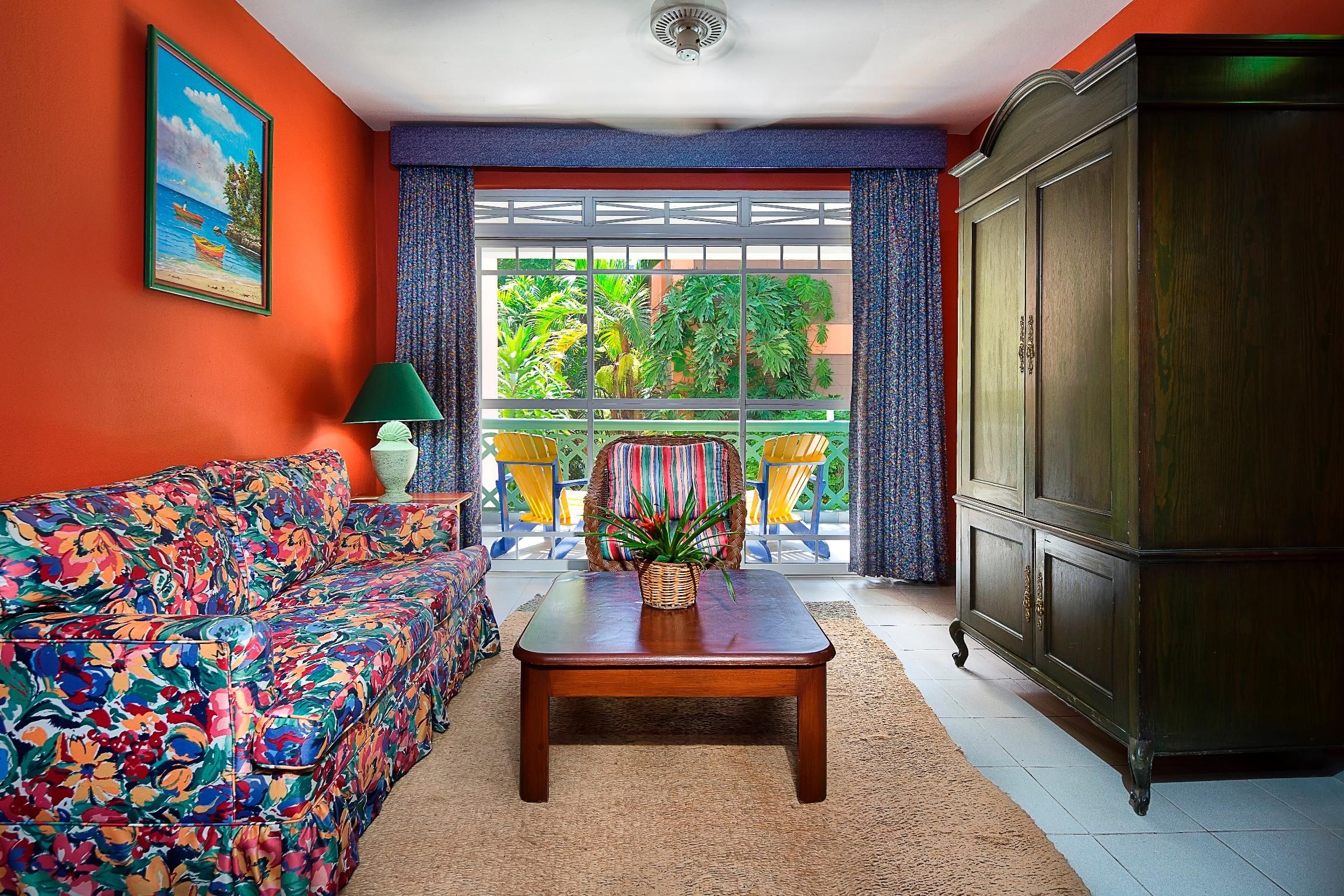 Una habitación con un sofá colorido, una mesa de centro de madera y un aparador.