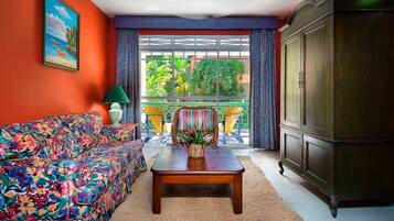 Una habitación con un sofá colorido, una mesa de centro de madera y un aparador.