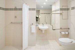 A modern bathroom with a shower, sink, and toilet.