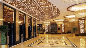 A lobby with a geometric floor design, chandeliers, and potted plants. - Central Hotel Shanghai (Shanghai)
