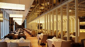 A long, narrow restaurant with tables set for dining, featuring a modern interior with patterned ceiling and walls. - Central Hotel Shanghai (Shanghai)