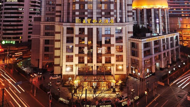 A high-rise hotel with a distinctive cylindrical top, multiple floors, and a central courtyard. - Central Hotel Shanghai (Shanghai)