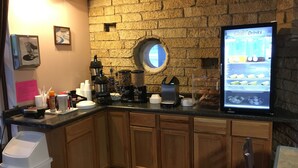 A kitchen area with a coffee machine, a blender, and a refrigerator displaying cold drinks. - St. Croix Suites - St. Croix Falls (St Croix Falls)