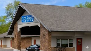 A building with a sign reading "St. Croix Suites" and a covered parking area. - St. Croix Suites - St. Croix Falls (St Croix Falls)
