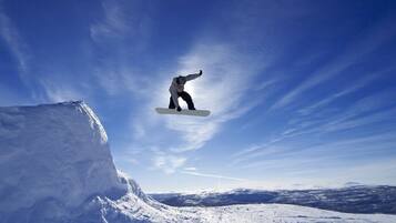 A snowboarder mid-air above a snowy mountain.