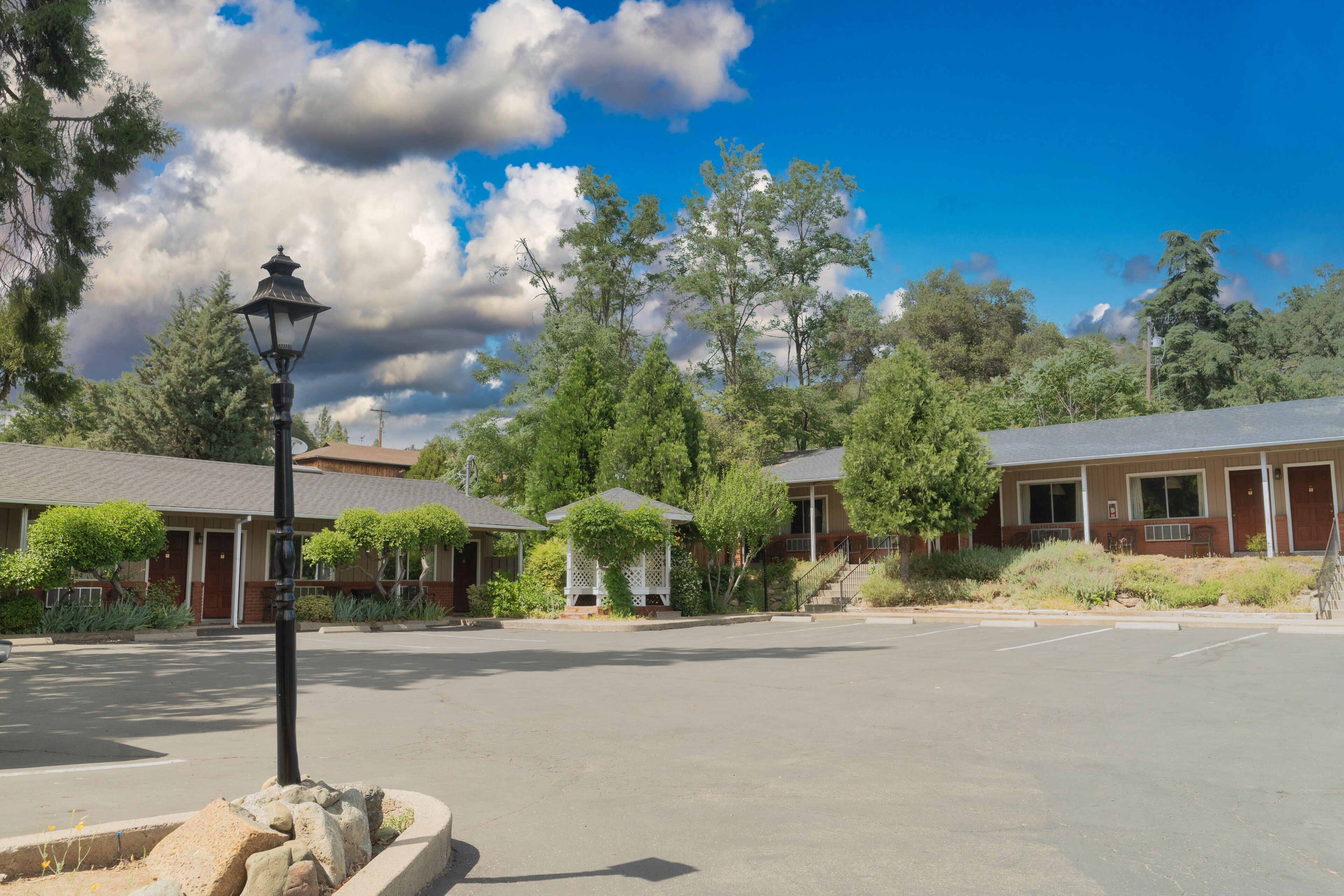 A parking lot with a building featuring a red roof and a white gazebo.