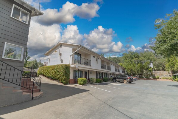 A two-story motel with a parking lot, a staircase, and a balcony. - Mariposa Lodge (Mariposa)