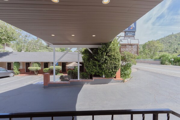 A motel with a covered parking area, a sign for 'The Mariposa Lodge', and a pool/spa WiFi sign. - Mariposa Lodge (Mariposa)