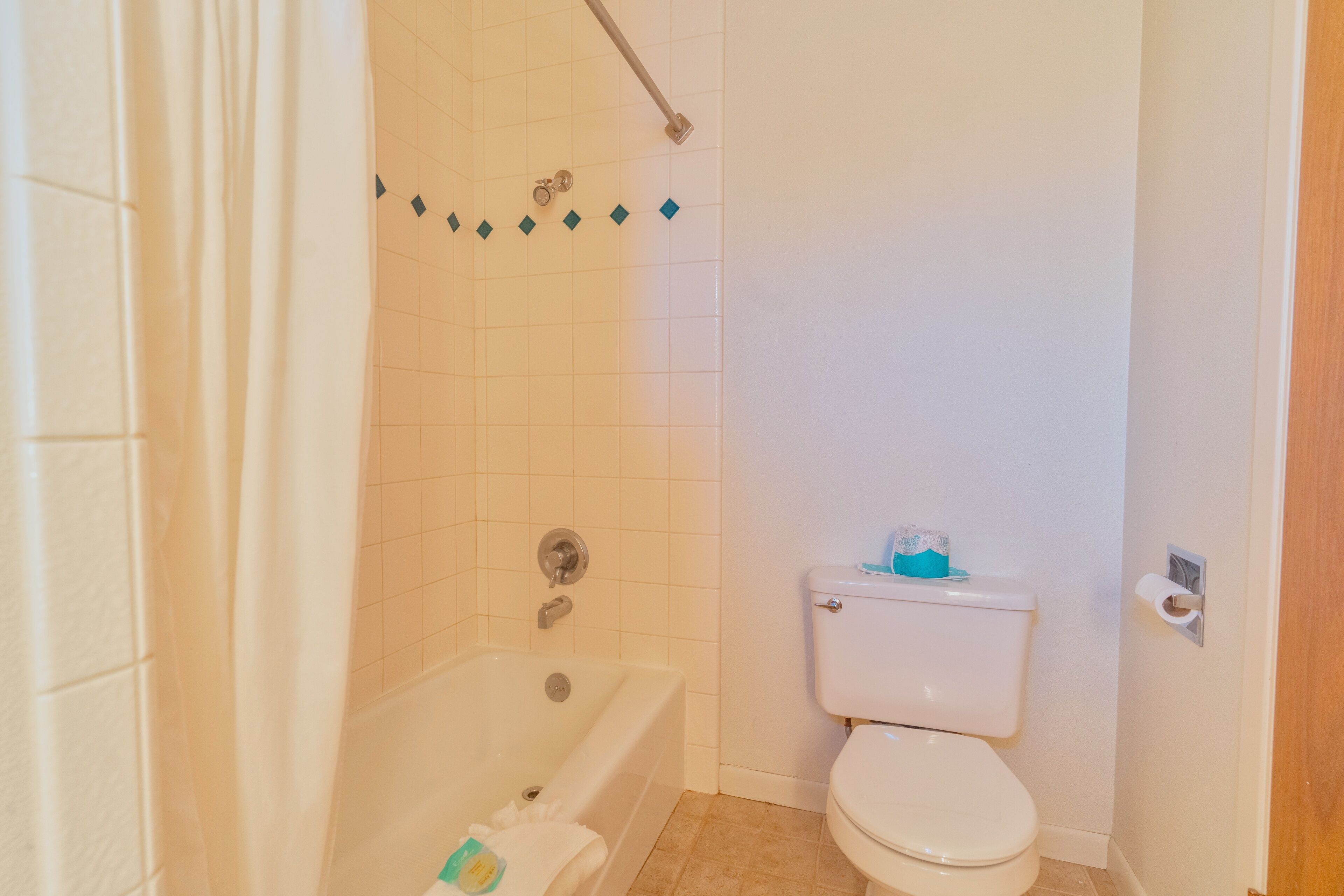 Een badkamer met een bad, toilet en douchegordijn.
