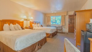 A hotel room with two beds, a desk, a chair, a wardrobe, and a television. - Mariposa Lodge (Mariposa)