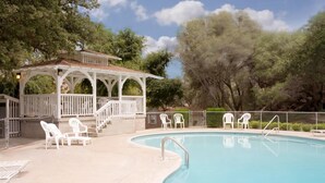 A swimming pool with a gazebo, white chairs, and a fenced area. - Lazy J Ranch Motel (Three Rivers)