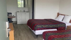 A room with two beds, a small desk, a cabinet, and a window. - Americas Best Value Inn Thousand Oaks (Thousand Oaks)