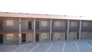 Un motel à plusieurs étages avec un parking.