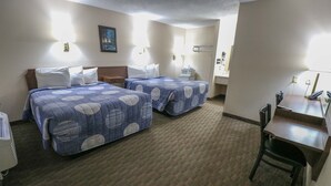 Une chambre d’hôtel avec deux lits, un bureau et une chaise.