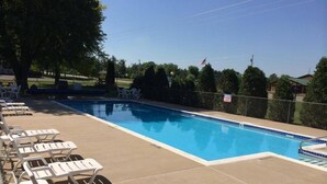A swimming pool with lounge chairs and a flag. - Day's End Motel (Wisconsin Dells)