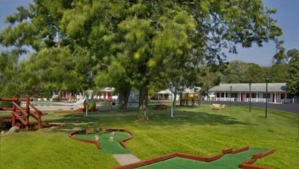 A park with a miniature golf course, a playground, and a building with a red roof. - Day's End Motel (Wisconsin Dells)