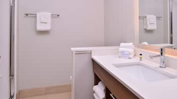 A modern bathroom with a white sink, a mirror, and a towel rack.