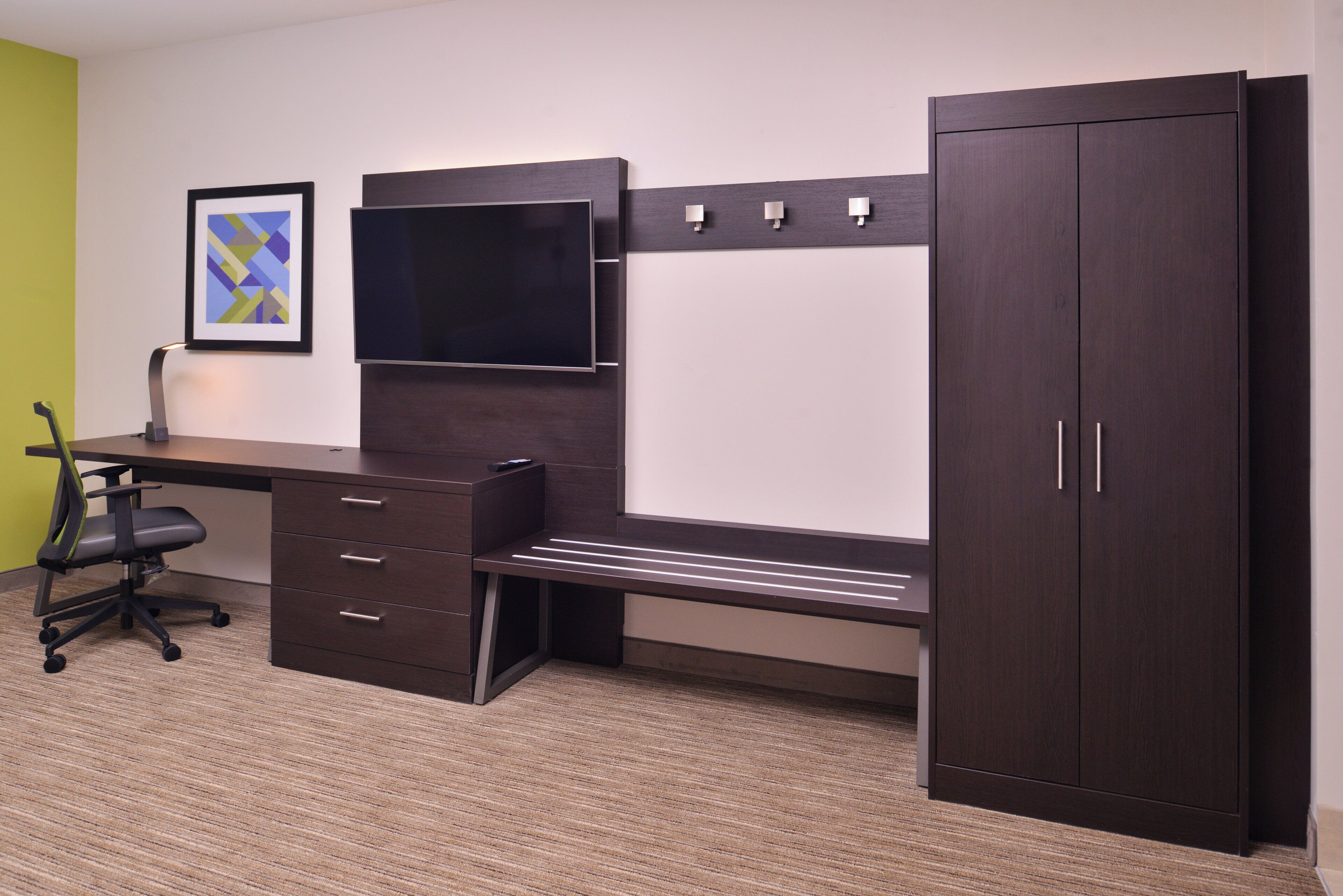 A modern office space with a desk, chair, and a cabinet.