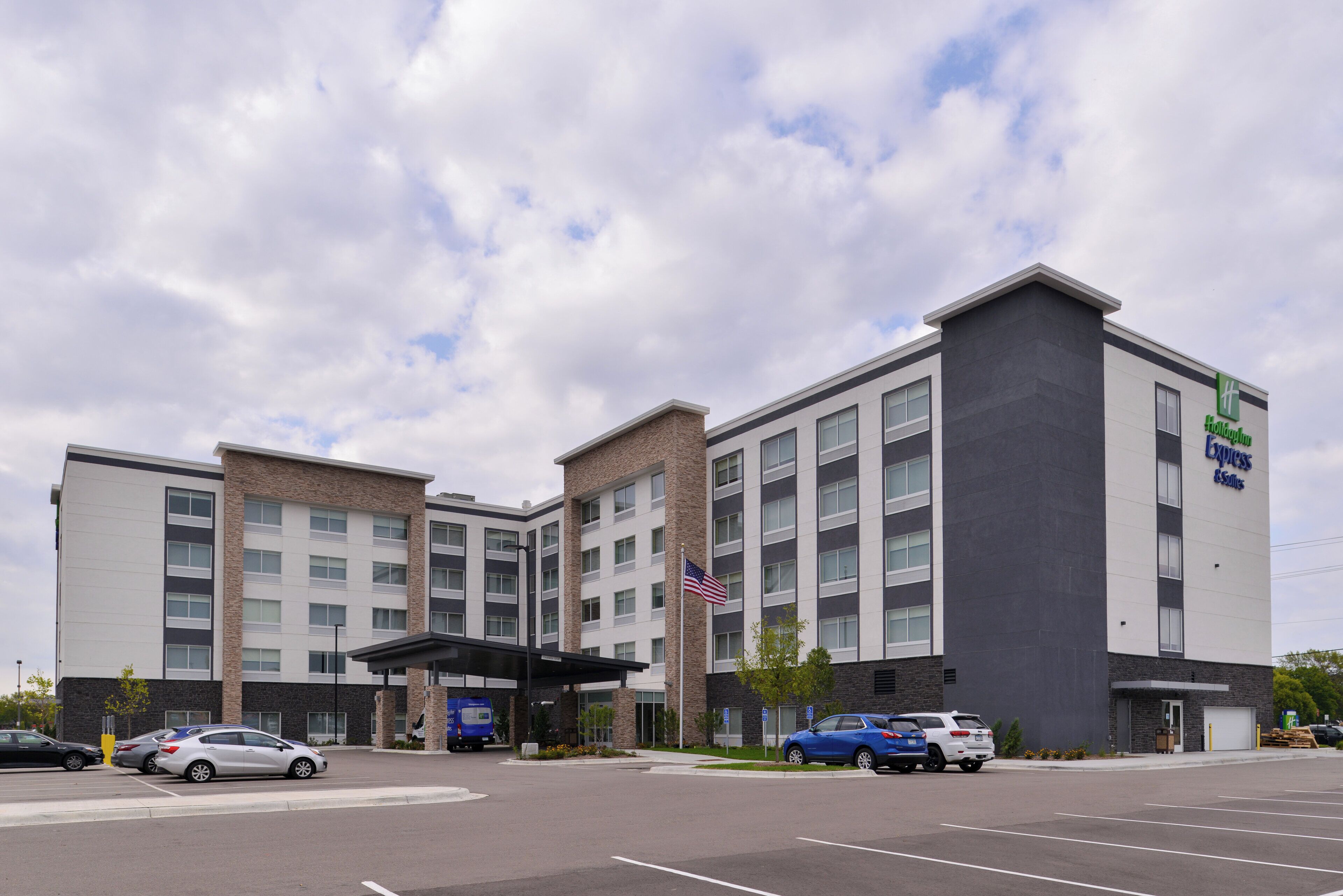 Edificio Holiday Inn Express con un design architettonico moderno, caratterizzato da un tetto piatto e un rivestimento in mattoni e cemento.