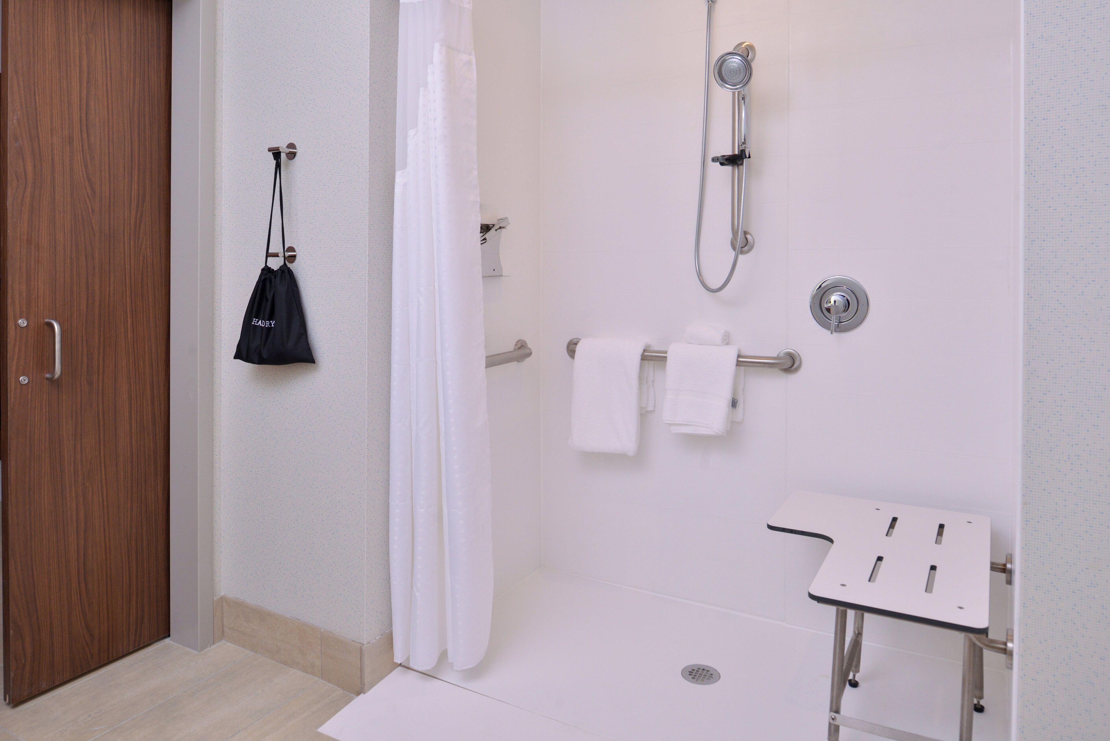Une salle de bain avec une douche, un lavabo et un porte-serviettes.