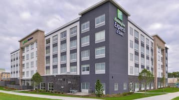 A multi-story hotel building with a modern design, featuring a prominent sign for Holiday Inn Express & Suites.