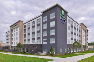 Un edificio de hotel de varios pisos con un diseño moderno, que presenta un letrero llamativo de Holiday Inn Express & Suites.